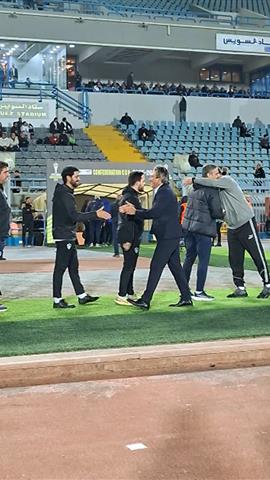 صوره ل نبيل الكوكي المدير الفني للمصري وجهازه المعاون يتوجهون لمعتمد جمال ودكة بدلاء الزمالك قبل المباراة